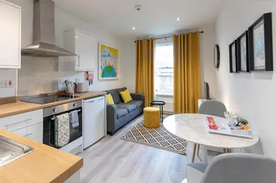 a kitchen and living room with a couch and a table at City Haven Preston in Preston