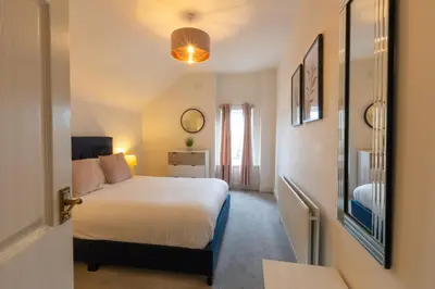 a bedroom with a white bed and a window at Fulwood Heights in Preston