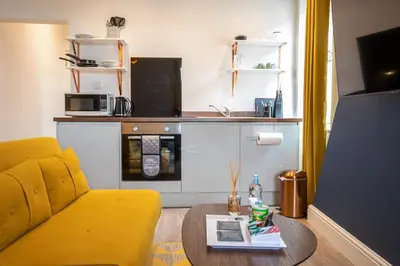 a living room with a yellow couch and a table at Fulwood Heights in Preston