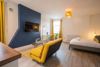 a living room with a yellow couch and a blue wall at Fulwood Heights in Preston