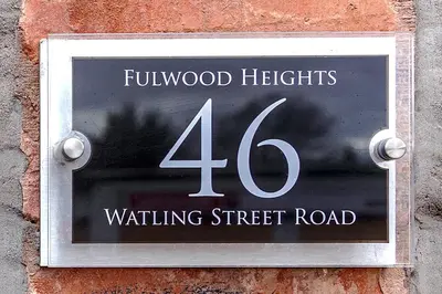 a sign on the side of a brick wall with the number fortyousand lights waiting at Fulwood Heights in Preston