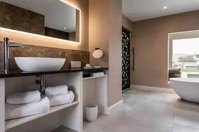 a bathroom with a tub and a sink at The Old Hay Shed in Cartmel