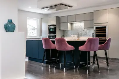 a kitchen with purple stools at a kitchen island at The Old Hay Shed in Cartmel