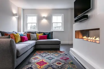 a living room with a couch and a fireplace at The Old Hay Shed in Cartmel