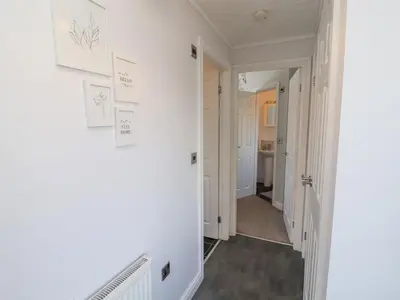 a hallway of a home with white walls at Duckling Lodge in Carnforth