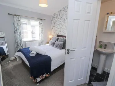 a bedroom with a bed and a sink and a door at Duckling Lodge in Carnforth