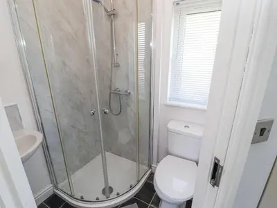 a bathroom with a shower with a toilet and a sink at Duckling Lodge in Carnforth