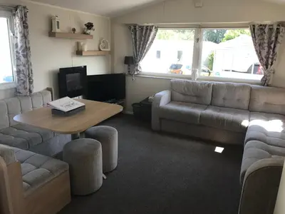 a living room with a couch and a table at Deluxe 3 bedroomed caravan on Marton Mere with CH DG and decking in Blackpool