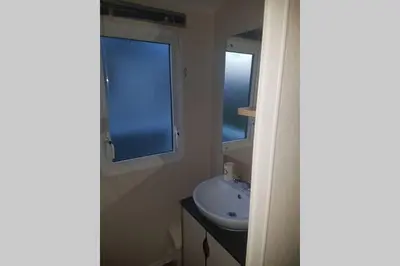a bathroom with a sink and a window at Deluxe 3 bedroomed caravan on Marton Mere with CH DG and decking in Blackpool