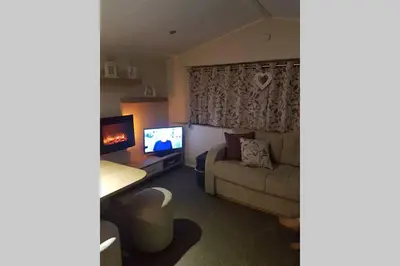 a living room with a couch and a television at Deluxe 3 bedroomed caravan on Marton Mere with CH DG and decking in Blackpool