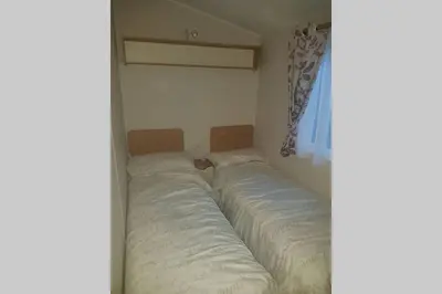 a bedroom with two beds in the corner at Deluxe 3 bedroomed caravan on Marton Mere with CH DG and decking in Blackpool