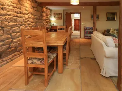 a wooden table and chairs in a living room at Usherwoods Barn in Lancaster