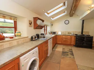 a large kitchen with a washer and dryer in it at Usherwoods Barn in Lancaster