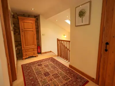 a hallway with a door and a rug on the floor at Usherwoods Barn in Lancaster