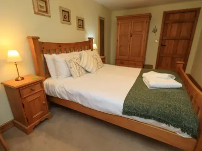 a bedroom with a large bed and a night stand at Usherwoods Barn in Lancaster