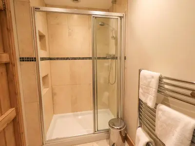 a shower with a glass door in a bathroom at Usherwoods Barn in Lancaster
