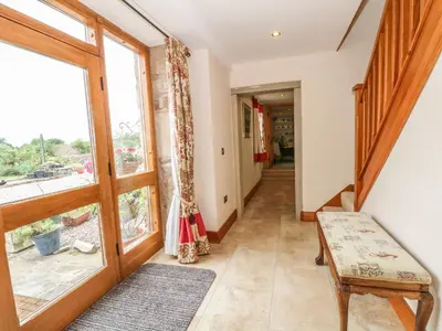 a hallway with a large window and a bench at Rose Hips Barn in Chorley