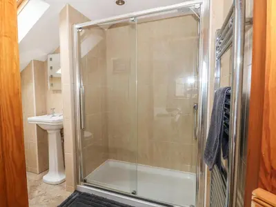 a shower with a glass door in a bathroom at Rose Hips Barn in Chorley