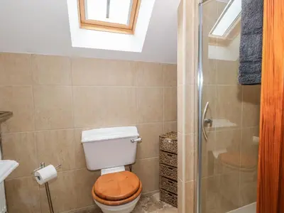 a bathroom with a toilet and a glass shower at Rose Hips Barn in Chorley