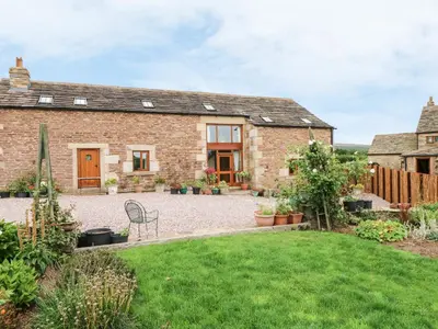 an external view of a brick house with a yard at Rose Hips Barn in Chorley