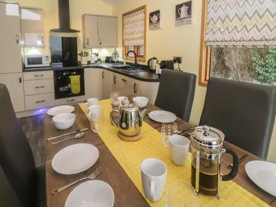 a kitchen with a wooden table with plates and utensils at Nicky Nook Lodge in Preston