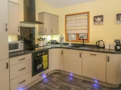 a kitchen with white cabinets and a stove top oven at Nicky Nook Lodge in Preston