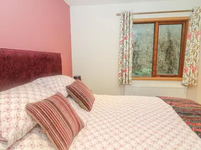 a bedroom with a bed with two pillows and a window at Nicky Nook Lodge in Preston