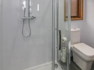 a bathroom with a glass shower with a toilet at Nicky Nook Lodge in Preston