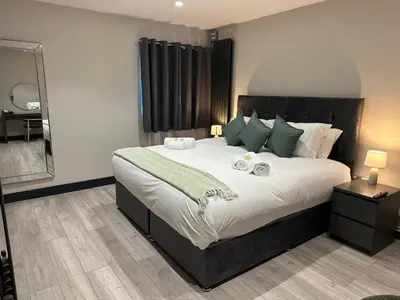 a bedroom with a large bed with green pillows at 6Adelphi in Preston