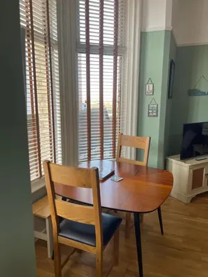 a dining room with a wooden table and two chairs at Beach House in Lytham St Annes