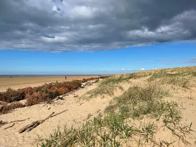 a beach with a cloudy blue sky and a beach at Beach House in Lytham St Annes