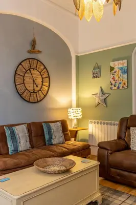 a living room with a couch and a clock on the wall at Beach House in Lytham St Annes
