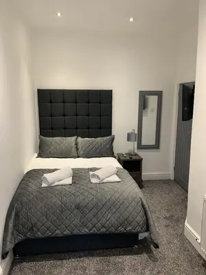 a bedroom with a large bed with two pillows on it at Victory hot tub house in Blackpool