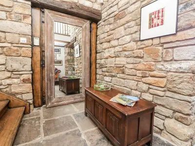 a room with a stone wall and a mirror at The Boot Room in Preston