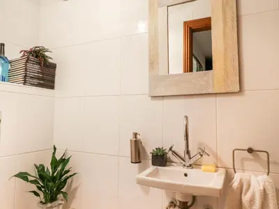 a white bathroom with a sink and a mirror at The Boot Room in Preston
