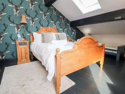 a bedroom with a bed and a wall with antlers at The Boot Room in Preston