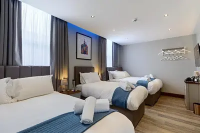 a hotel room with three beds in it at The Arc Hotel in Liverpool
