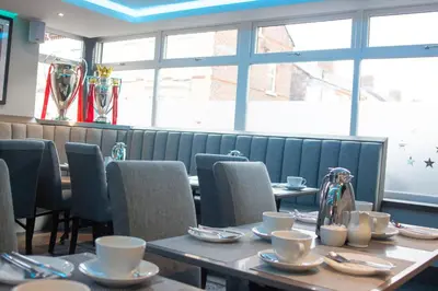 a dining room with tables and chairs and windows at The Arc Hotel in Liverpool