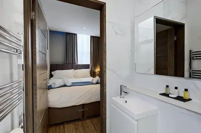 a bathroom with a bed and a sink and a mirror at The Arc Hotel in Liverpool
