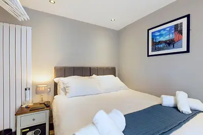 a bedroom with a large bed and a nightstand with a bed sidx sidx sidx at The Arc Hotel in Liverpool