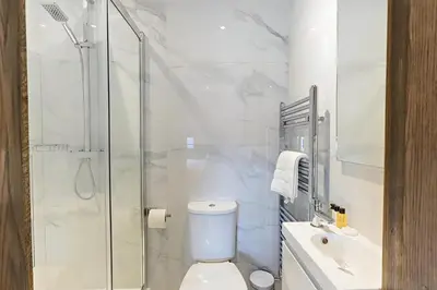 a bathroom with a shower and a toilet and a sink at The Arc Hotel in Liverpool