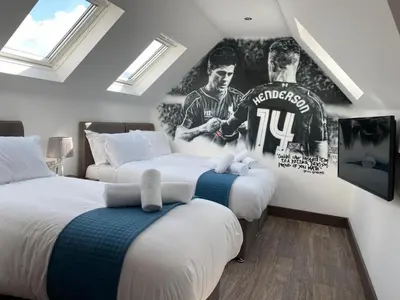 two beds in a room with two hockey posters on the wall at The Arc Hotel in Liverpool
