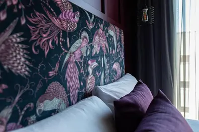 a headboard of a bed with a floral wallpaper at The Baltic Hotel in Liverpool