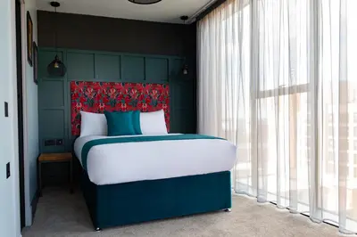 a bedroom with a bed with a red headboard at The Baltic Hotel in Liverpool