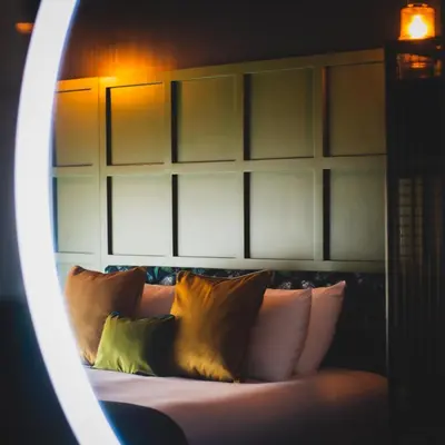 a bedroom with a bed with pillows and a mirror at The Baltic Hotel in Liverpool