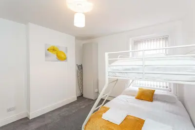 a bedroom with a bunk bed with a ladder at Cherry Property - Hornby Road in Blackpool