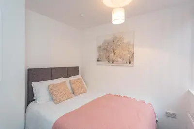 a bedroom with a bed with a pink blanket at Cherry Property - Hornby Road in Blackpool