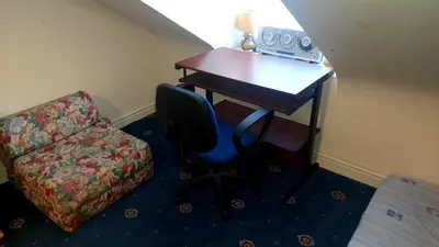 a desk in a room with a chair and a couch at Phoenix Nights Guest House in Barrow in Furness