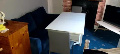 a white desk and a blue chair in a room at Phoenix Nights Guest House in Barrow in Furness