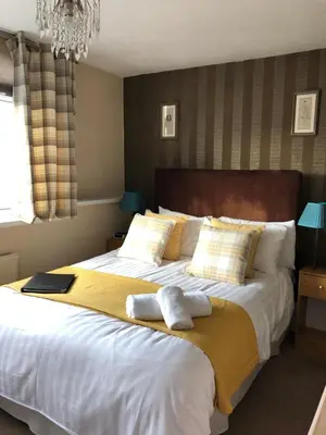 a bedroom with a large bed with towels on it at Adelphi Guest House in Southport